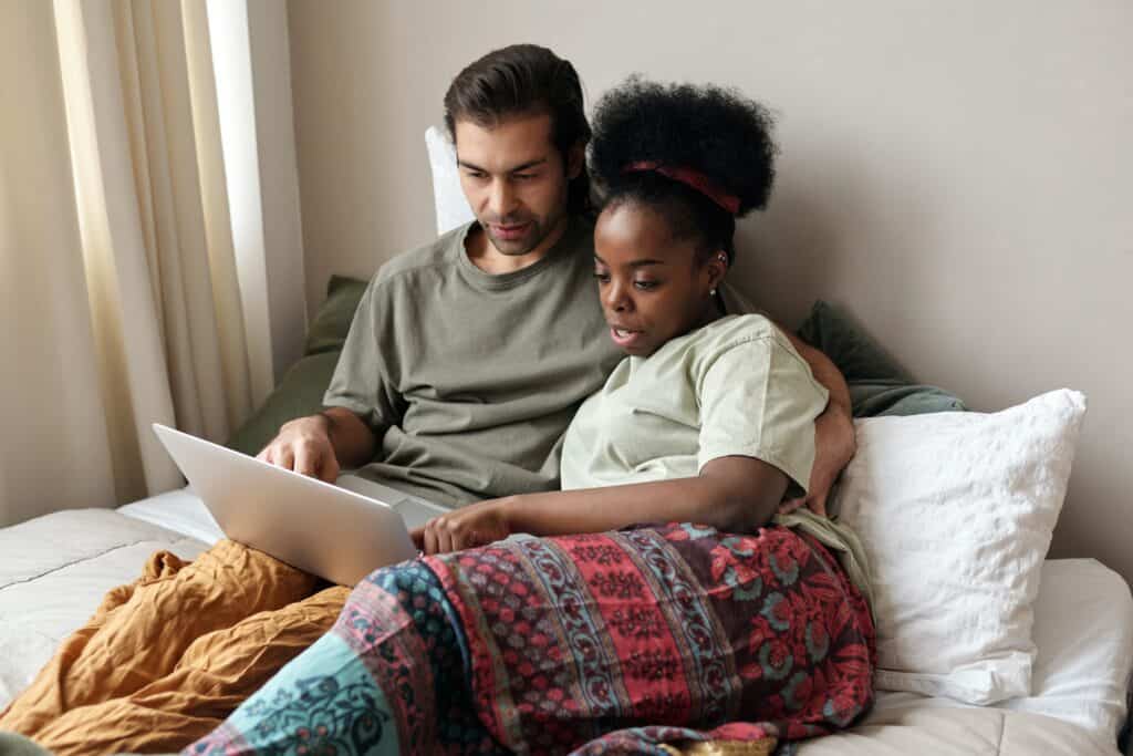 pareja con una computadora portátil en la cama 4046110